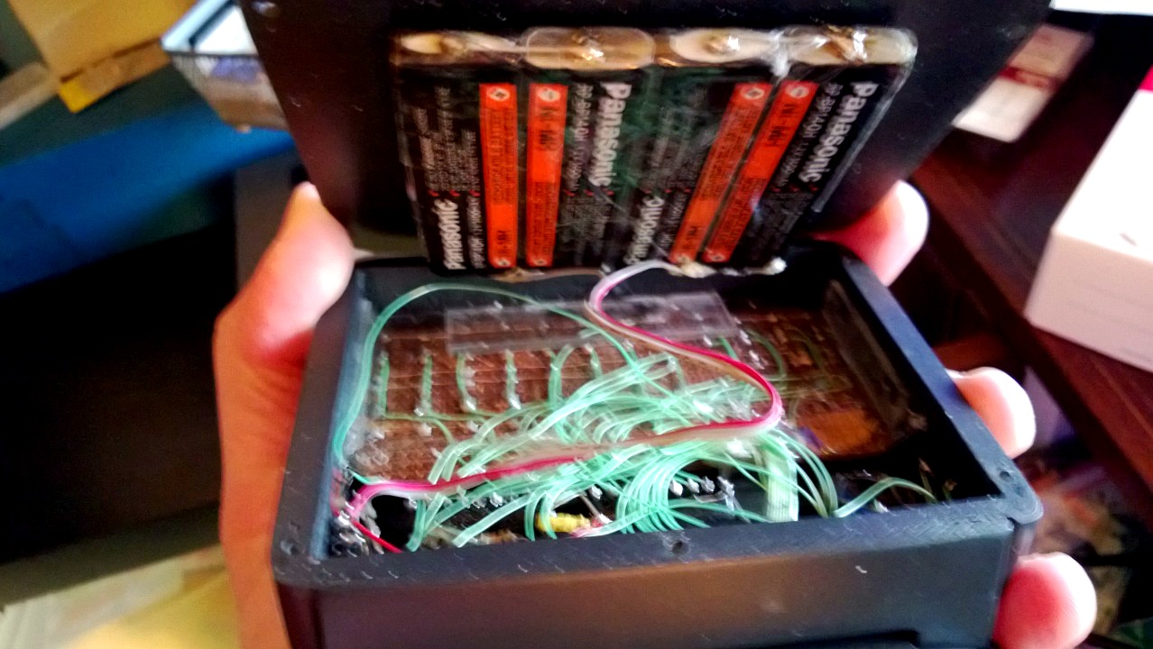 Opened hand-soldered Sirius prototype showing batteries and wiring